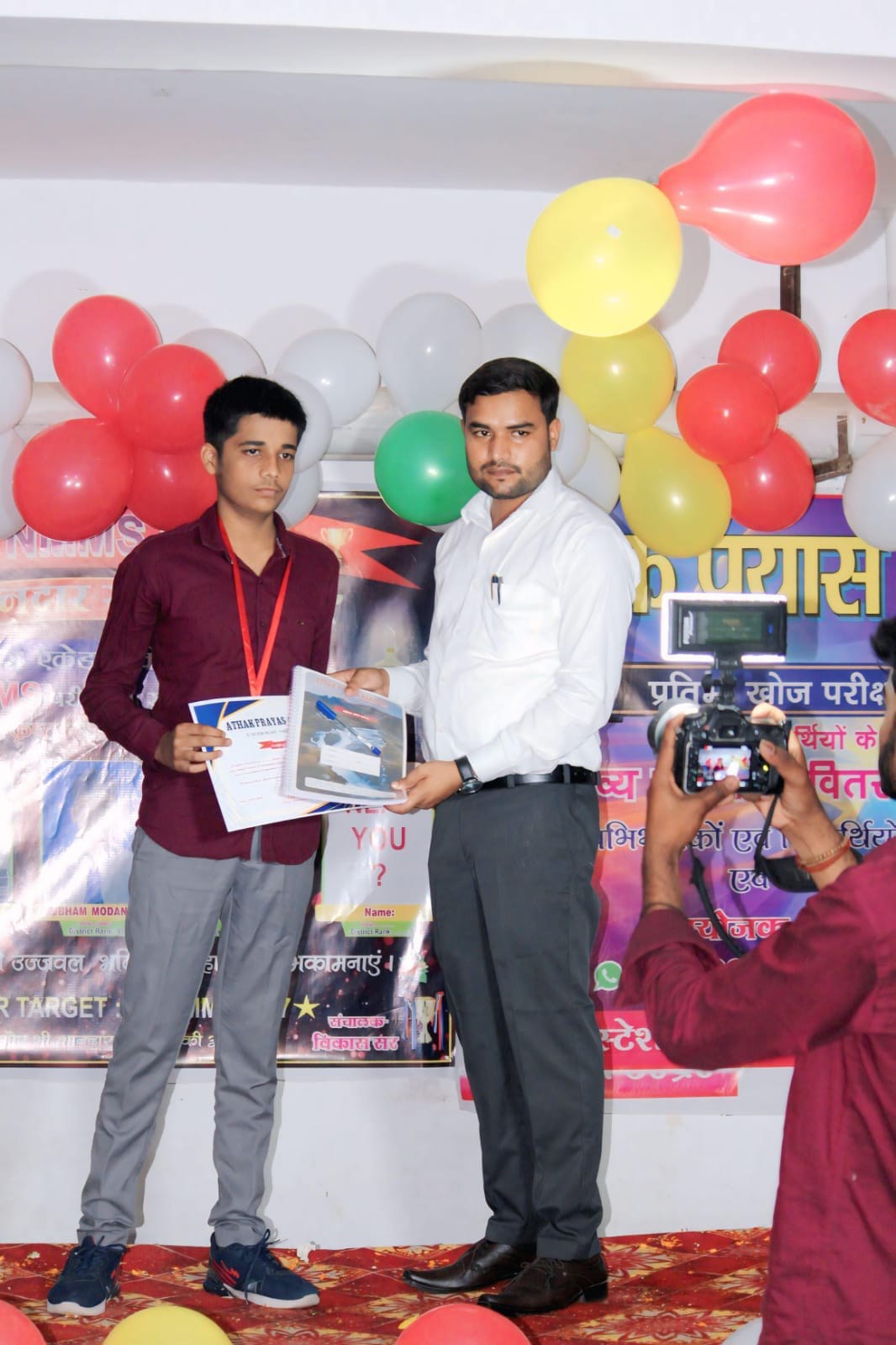 A student receives a book and certificate from the academy teacher