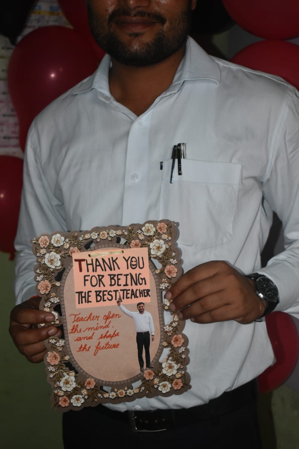 An academy teacher holds a thank-you gift from students